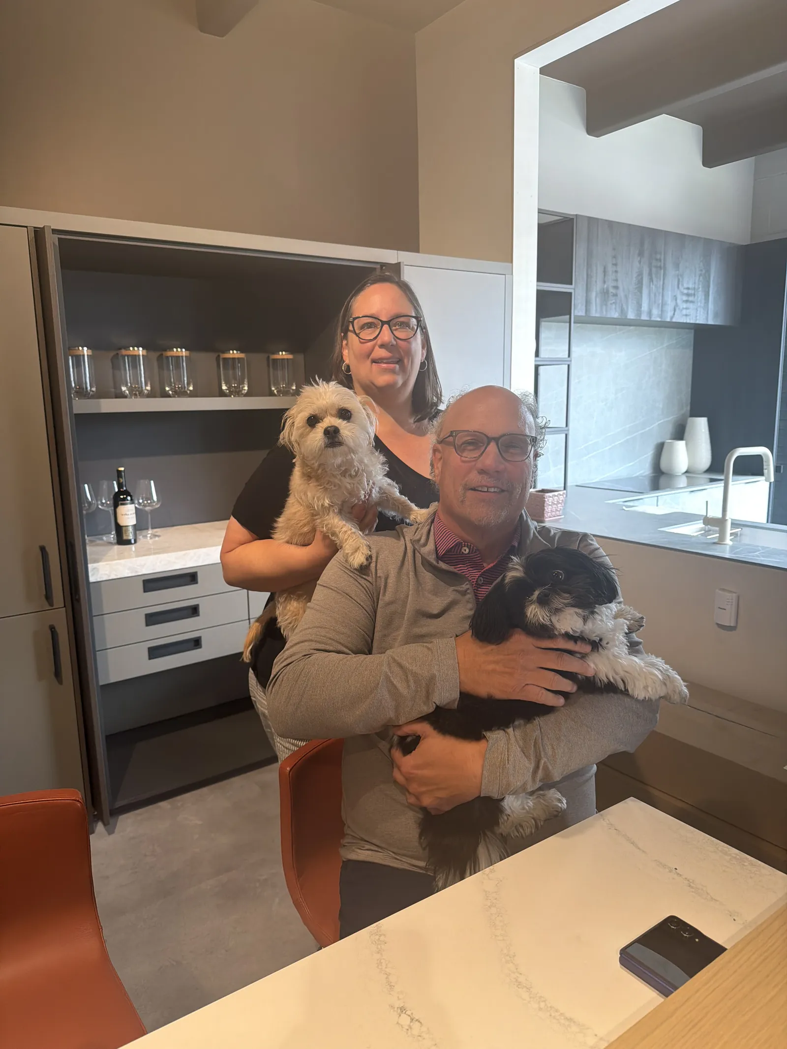 Pinnacle Sales meeting with the Colorado Modern Kitchens team around the showroom island — sample boards laid out, laptops open to the new dealer portal