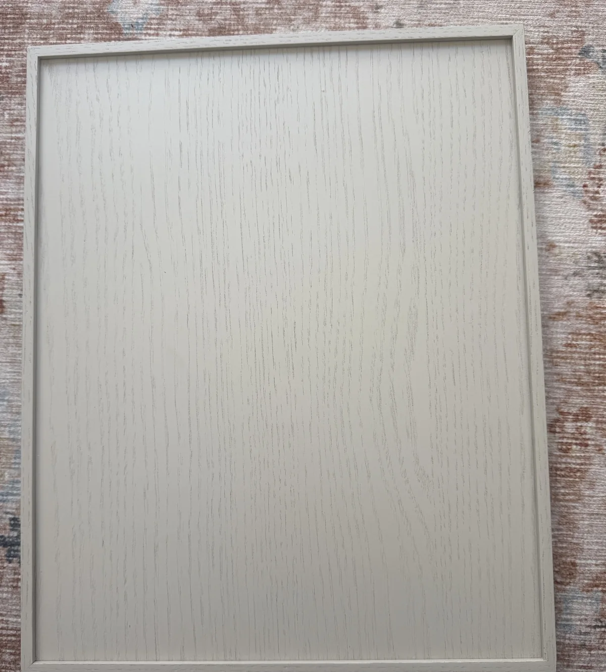 Ventura flat panel door in Warm Stone stain on White Oak, showing the slim square applied moulding framing a straight-grain oak panel