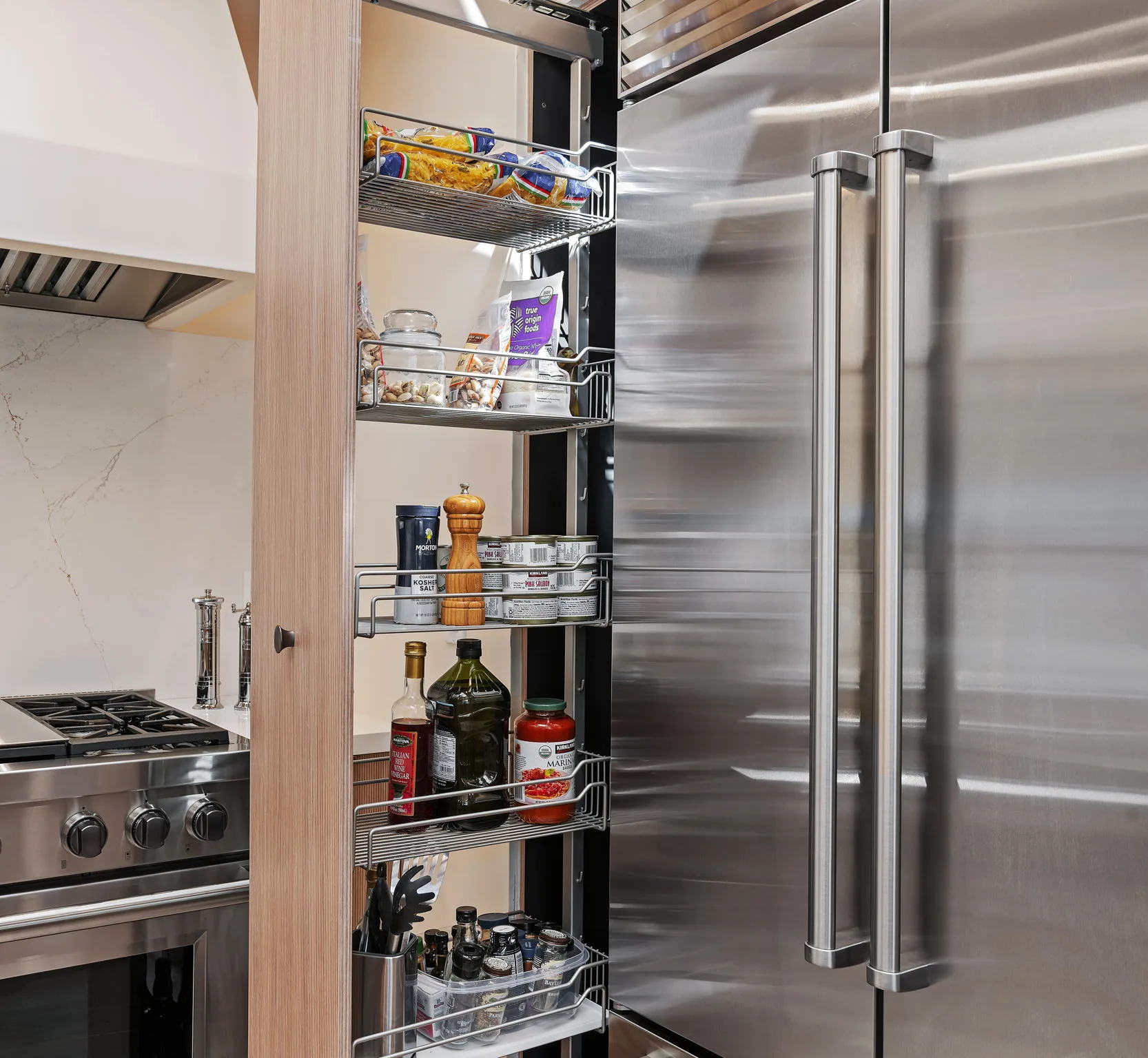Tall pantry pullout beside the Sub-Zero showing interior wire shelving