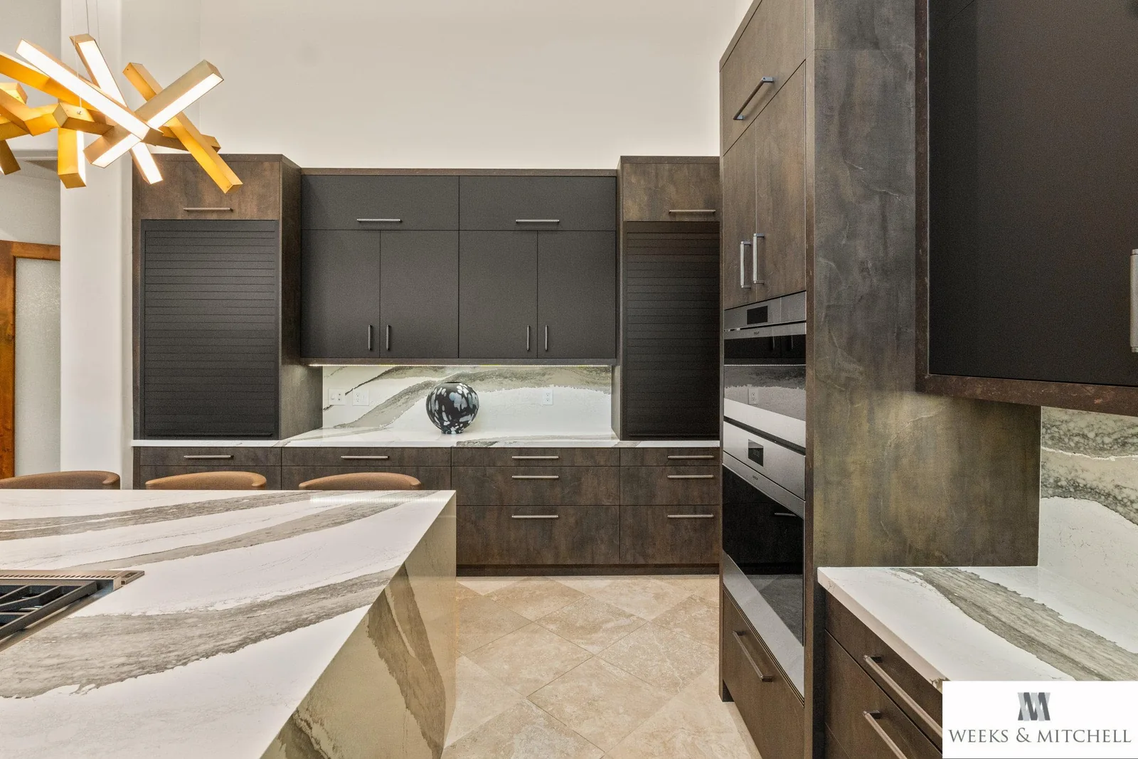 Detail of Pronorm Ultra Matte Black Lacquer wall cabinets above Dark Steel base cabinets and a veined marble backsplash