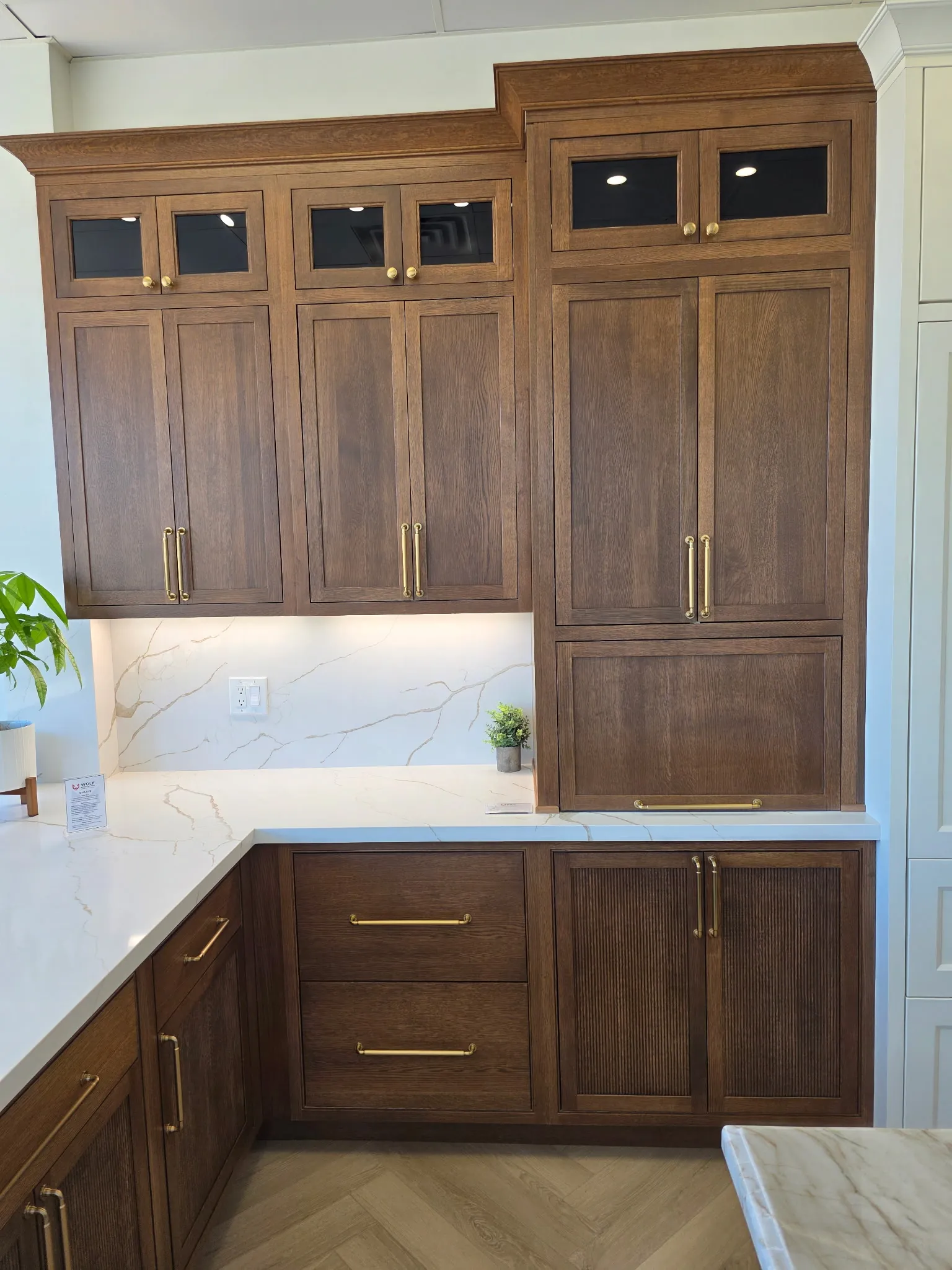 Quarter Sawn White Oak built-in hutch in the Braun finish — glass-front transom uppers, Malibu Reeded base doors, marble backsplash, antique-brass pulls
