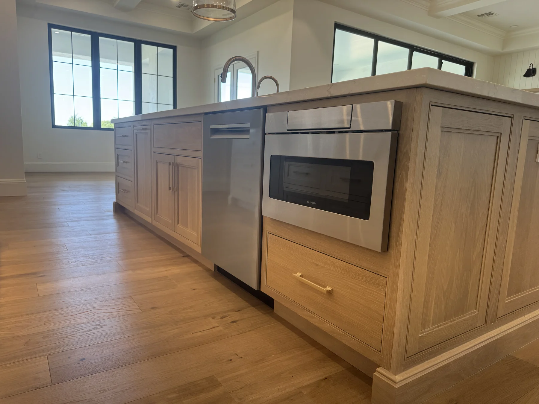 Silverstone Queen Creek kitchen — island detail in stained white oak with paneled dishwasher, microwave drawer, and warming drawer