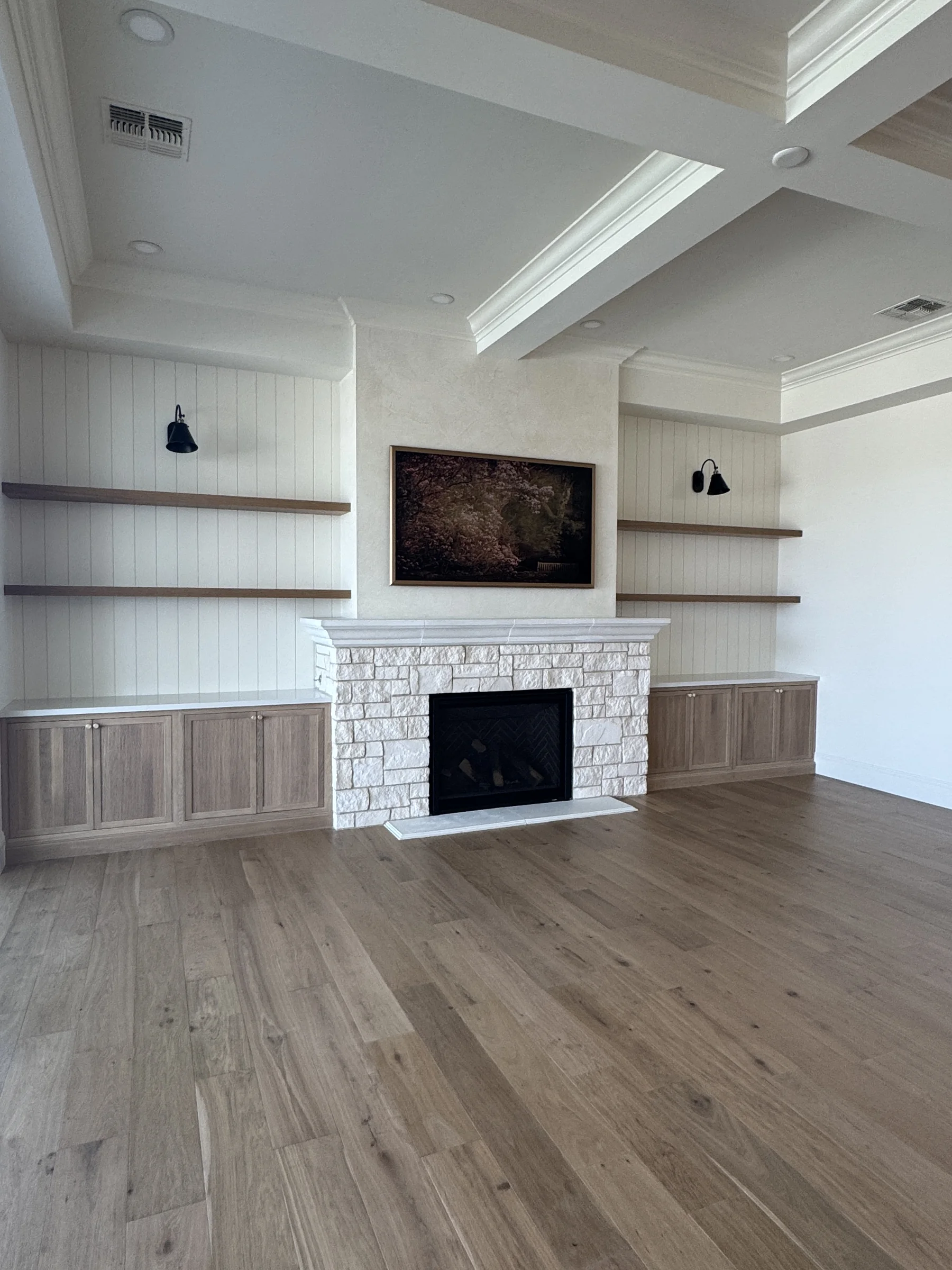 Silverstone Queen Creek family room — stone fireplace flanked by white oak built-in cabinetry and shiplap walls