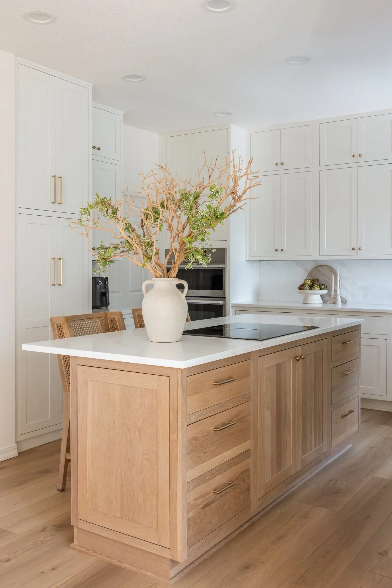 Stutler Cabinets Hanover kitchen — close-up of the Hanover door style on the Straw white oak island, brass bar pulls and knobs