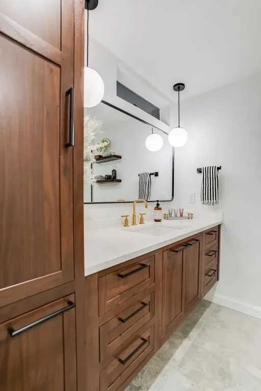 Stutler Cabinets master bath — side angle showing the linen tower in profile and the full double vanity run